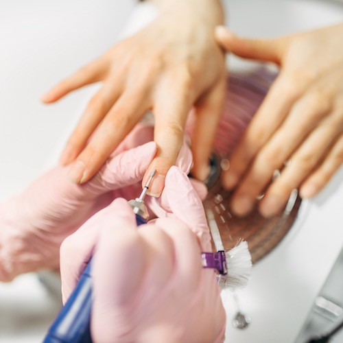 Our manicurist wearing gloves and displaying superior nail hygiene standards